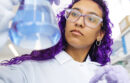 Purple-haired scientist holding a beaker