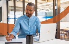 Man working on a laptop computer and digital tablet