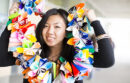 Student wearing a lei made out of colorful folded paper