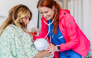 A nurse helps a mother with a newborn baby at the UC San Diego Medical Center