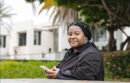 staff person holding their cellphone and sitting outside at UC Santa Barbara