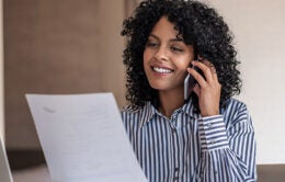 Woman talking on the phone about a paper she's holding
