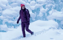 Woman walking through snow in the woods