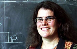 Andrea Ghez by a chalkboard in the 80s