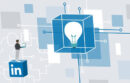 Illustration of a man standing on the LinkedIn logo holding a cellphone and looking at a giant lightbulb in a translucent box