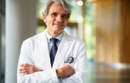 Stephen L. Hauser, wears a white lab coat