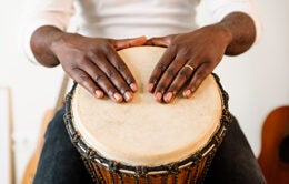 Musician playing a drum with his hands.