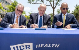 Garry Spanner, president of Canyon Springs Marketplace Corp, UC Riverside Chancellor Kim Wilcox and UC President Michael V. Drake sign a letter of intent.