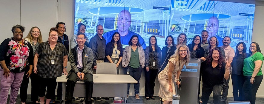Group of people standing together at the front of a room