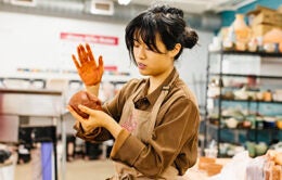 Berkeley student hand-molding a clay pot