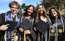 Four students in caps and gowns