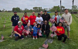 Group of people holding American flags in a cemetery
