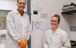 Two scientists standing side by side and smiling