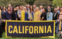 Group of people holding a large banner with the word “California.”