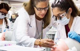 Dentistry professor instructs student on dental model