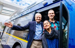 Three people standing on an electric bus at UC Irvine