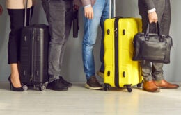 Group of people with suitcases going on business trips or holidays, standing in line at the airport, waving hands, and saying goodbye