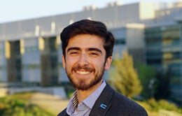 Miguel Craven standing outdoors and wearing a UC pin