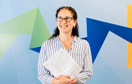 Smiling woman holding paperwork