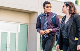 Two students in their 20s walking on campus