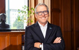 Smiling Pres. Milliken in a wood-paneled library