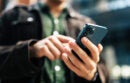 Close-up hands of unrecognizable man holding and using smartphone