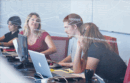 People having a discussion while working on laptops