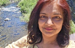 Sneha Patel standing outside, in nature, by a stream