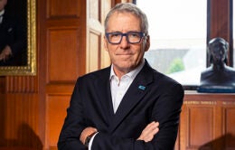UC President James B. Milliken in a wood-paneled room