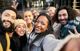 Selfie of a group of happy business people taking photo with a phone.