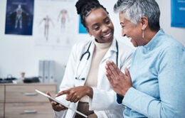 Black woman doctor and elderly patient with good news,