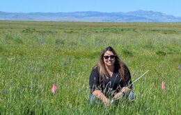 Tracy kneeling in a field