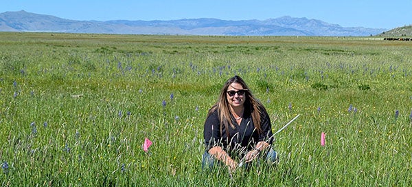 Tracy kneeling in a field