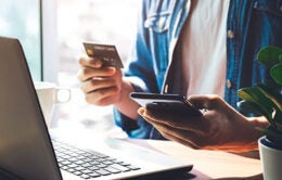 Person using a credit or debit card to shop online