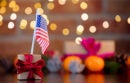 gift box and flag of the USA on background with fairy lights