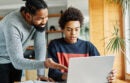 Father and son doing homework with laptop at home. Father and teenage son using laptop. Boy and dad sitting at home working with notebook