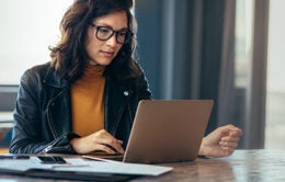 Businesswoman busy working on laptop computer at office.