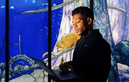 Man working on a laptop near a stained glass window