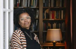 Leigh Raiford standing in the doorway to a personal library