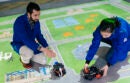 Researchers with model electric cars on a map board