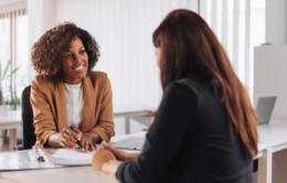 Manager speaking with employee at desk