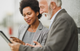 Man and woman professionals looking at a tablet together
