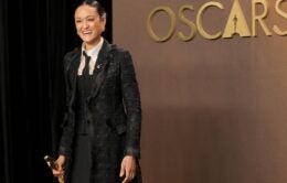 Smiling woman in suit holding Academy Award