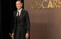 Smiling woman in suit holding Academy Award