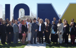 Group of people standing in front of the UC Merced sign