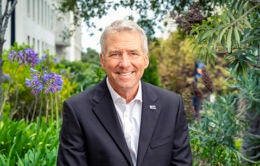 Smiling President James B. Milliken outside in a garden