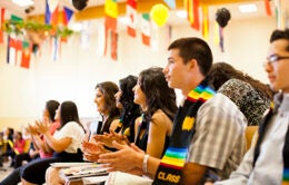 UC Puente Program at graduation celebration surrounded by international flags