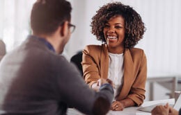 Happy businesswoman shaking hands with colleage after successful meeting