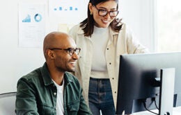 Colleagues working together at an office computer