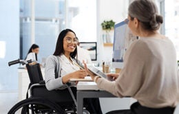 Woman in a wheelchair having a conversation with a woman sitting on a chair